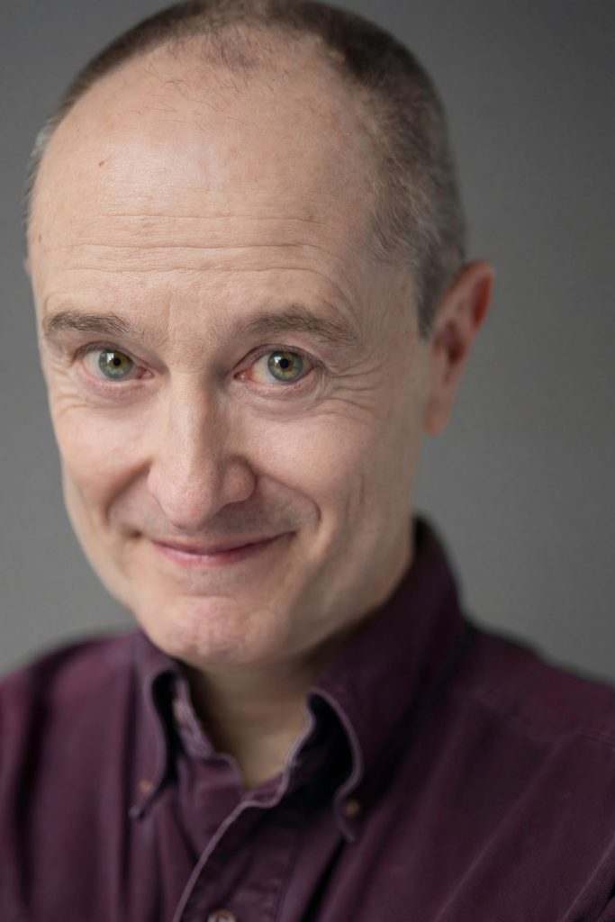 Andrew Sellon Commercial Headshot with Big Eyes and Playful Smile. Photo: Will O’Hare Photography